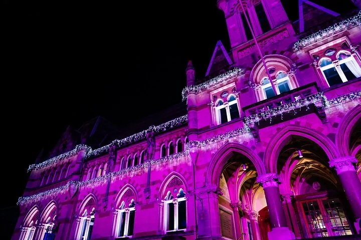 A building illuminated in bright purple light at night.