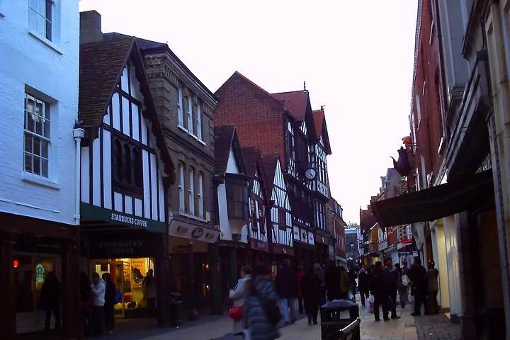 A street scene with various buildings and people walking.