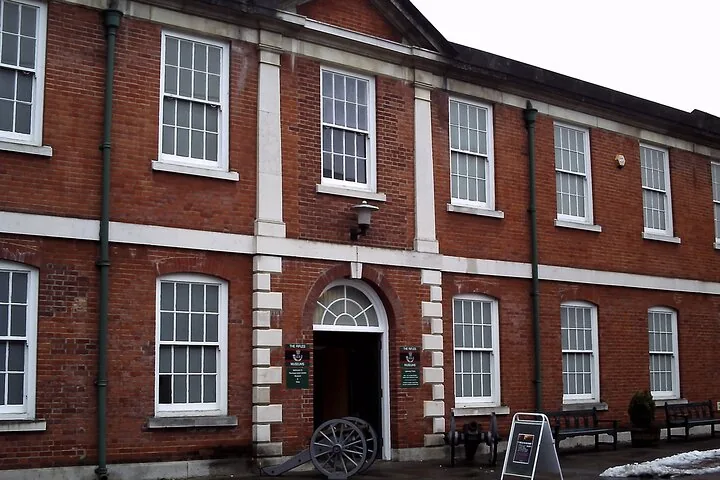 A large brick building with a sign that says The Rifles.